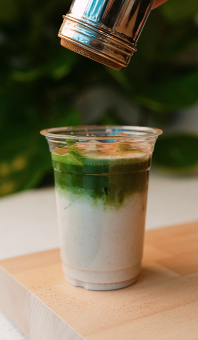 Matcha latte siendo espolvoreado